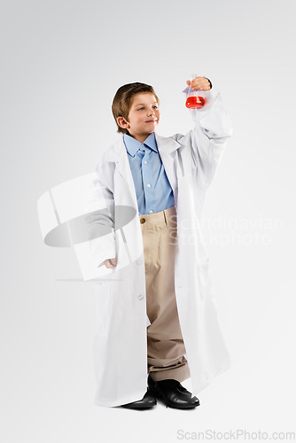 Image of Science, chemicals and boy child in studio doing a chemistry experiment, project or discovery. Liquid, glass beaker and full body of kid scientist model doing scientific research by white background.