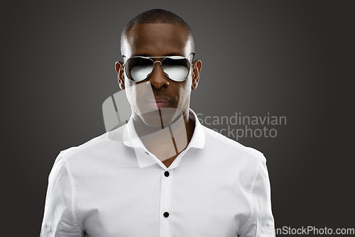 Image of Confidence, portrait of a black man with sunglasses and against a dark background for fashion. Gentleman or mock up space, elegance and African male person pose with eyewear against studio backdrop