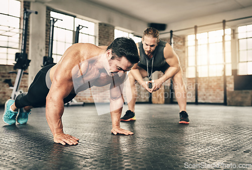 Image of Sports, personal trainer and man doing a push up workout for strength, health and wellness. Fitness, training and male athlete doing a body building arm exercise with a coach for motivation in a gym.