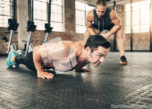 Image of Fitness, personal trainer and athlete doing a push up exercise for strength, health and wellness. Sports, training and male person doing a body building arm workout with a coach for motivation in gym