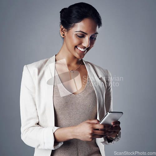 Image of Corporate, smile and woman with a smartphone, social media and search internet on a grey studio background. Female person, entrepreneur and model with a cellphone, website information and connection