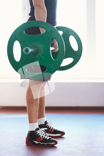 Image of Man, shoes and hands weightlifting in a gym with athlete wellness and healthy from workout. Fitness, bodybuilder and male person with weights power from strong arm muscle and training at health club