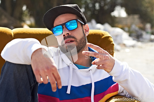 Image of Trendy fashion, portrait of a man with peace sign and sunglasses outdoors on couch. Freedom or youth, relax or hip hop and male person with emoji hand gesture for urban culture outside on sofa