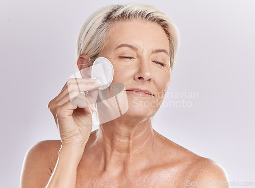 Image of Senior woman, beauty and eyes closed, cotton pad and natural cosmetics with antiaging skincare on white background. Clean makeup from face, wellness and skin, female model with glow and dermatology