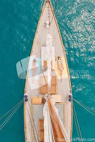 Image of Travel, ocean and women on boat for cruise, luxury sailing and transport for holiday, vacation and trip. Relax, summer and aerial of female people on yacht for tropical journey, sunbathing or tourism