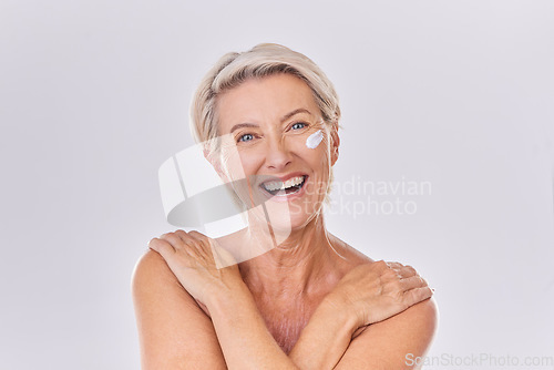 Image of Smile in portrait, old woman and cream on face, beauty with antiaging skincare and dermatology on white background. Sunscreen, moisturizer and female model, lotion and skin glow with facial in studio