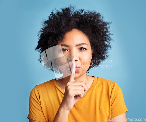 Image of Secret, quiet and shush with portrait of woman in studio for noise, privacy and gossip. Communication, announcement and whisper with face of person on blue background for voice, sign and rumor