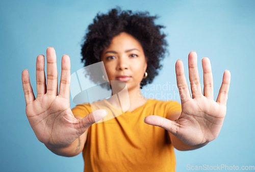 Image of Portrait, stop hands and serious woman in studio isolated on a blue background. African person, face and ban, rejection or warning, refuse and no palm sign to protest racism, human rights and emoji.