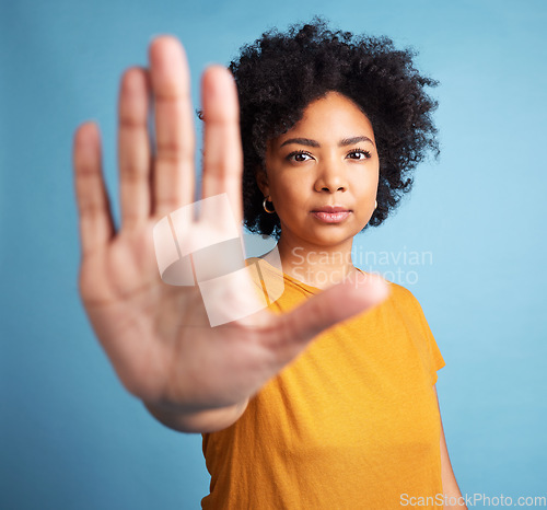 Image of Stop hand, serious woman and portrait in studio isolated on a blue background. African person, face and ban, rejection or warning, refuse and no palm sign to protest racism, human rights and emoji.