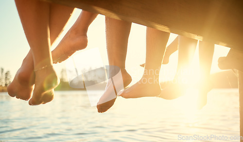 Image of Group, feet on water and friends together at ocean, pier or outdoor in summer, vacation or freedom in holiday break. Teen, foot and children to relax at the lake, harbor or river on the weekend