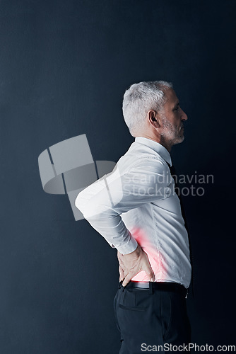 Image of Injury, feeling and a businessman with back pain at work, spine problem and tired from stress. Serious, backache and a mature corporate employee touching body isolated on a black background in studio