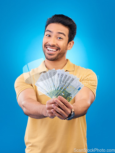 Image of Cash, portrait and happy man or winner for bonus offer, financial success and winning, finance loan or lottery fan. Young asian person with savings, money or profit isolated on studio blue background