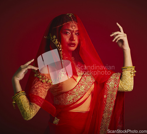 Image of Fashion, beauty and portrait of Indian woman with veil in traditional clothes, jewellery and sari. Religion, culture and face of female person on red background with accessory, cosmetics and makeup