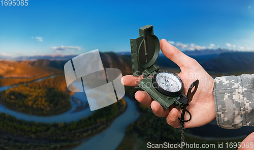 Image of Man with compass n Altai mountains