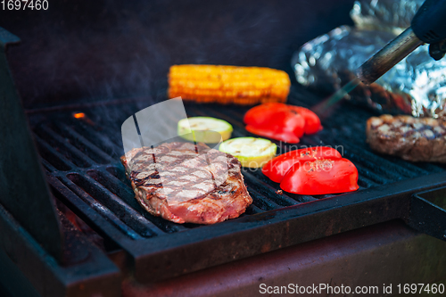 Image of Beef steaks on the grill with flames