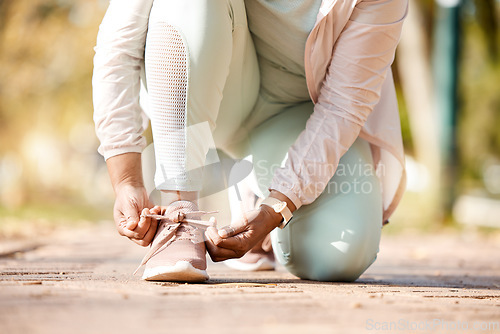 Image of Fitness, feet and person tying laces for exercise, workout and outdoor training ready for wellness and health. Sneakers, shoes and woman or runner prepare footwear for running, sports and marathon