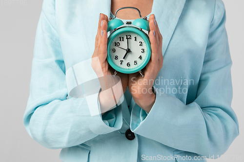 Image of Woman holding clock in the hand