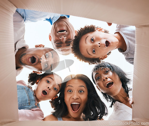 Image of Family, open box and surprise from below with smile, portrait and circle for present, together and excited in home. Happy men, women and children with package, gift and wow with grandparents in house