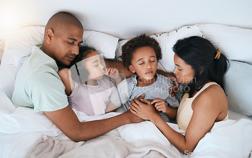 Image of Parents, children and bed for sleeping together, dream and bonding with love, care and rest in family home. Father, mother and young kids in bedroom, safety or security with embrace for rest in house