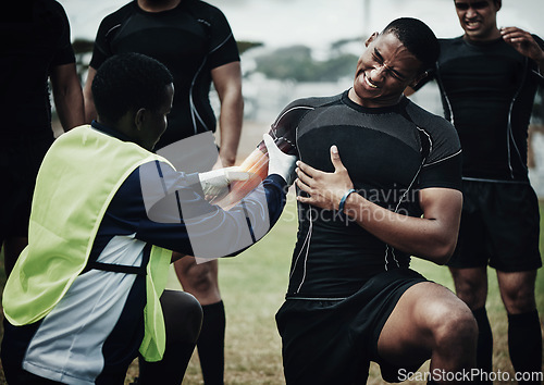 Image of Rugby player, muscle injury and field with pain, team doctor and broken bone in game, overlay and helping hand. Athlete, emergency or accident with sports medic, torn bicep and red glow for fitness