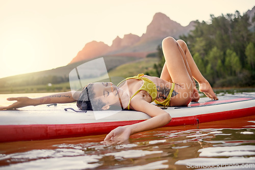 Image of Relax, happy and a woman on a board in a lake for freedom, travel and water activities. Calm, summer and a young girl in a river for adventure, zen and vacation by the dam for relaxing at sunset