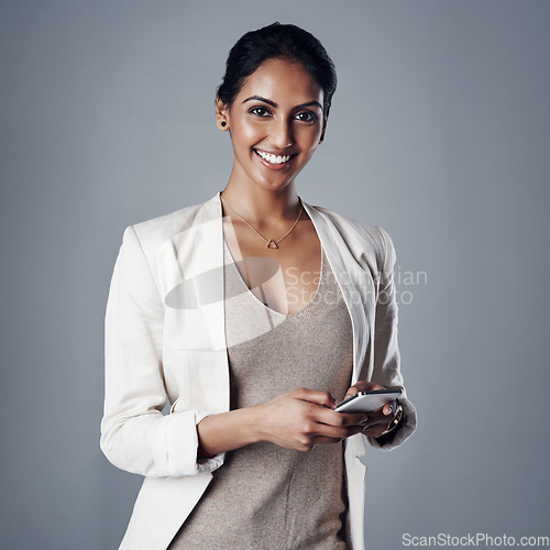 Image of Technology, portrait of a woman with smartphone and against a studio background for social networking. Online communication, typing and Indian accountant person with cellphone pose for connectivity