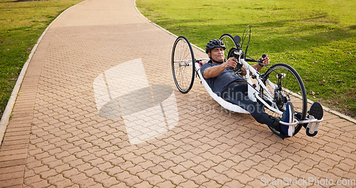 Image of Cycling, disability and challenge with man and bike with handicap for training, sports and fitness. Exercise, workout and wheelchair with disabled person training in park for cardio and health