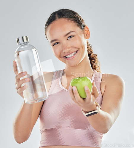 Image of Portrait, woman and fitness with apple, water and in studio for diet of healthy food, nutrition and detox for wellness goals. Happy sports model, hydration or fruit to lose weight on white background