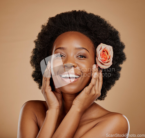 Image of Happy, flower and portrait of a black woman with skincare, clean glow and wellness. Smile, touching face and an African model with floral beauty for skin isolated on a brown background in a studio