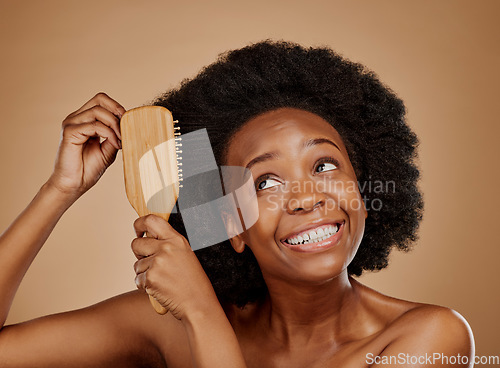 Image of Black woman, hairstyle and smile for brush in studio, brown background and treatment for curly texture. Natural beauty, confidence and happy young african female model comb clean or healthy afro hair