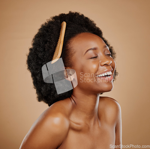 Image of Hair, comb and a model black woman laughing in studio on a brown background for beauty or cosmetics. Funny, afro and haircare with an attractive young female person feeling excited for natural care