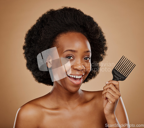 Image of Portrait, hair and comb with a model black woman in studio on a brown background for beauty or cosmetics. Smile, afro and haircare with a happy young female person looking excited for natural care