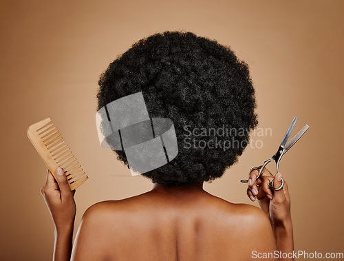 Image of Back, comb and scissors with a black woman in studio on a brown background for a haircut. Salon, afro and haircare with a natural female model at the hairdresser for hairstyling or beauty from behind