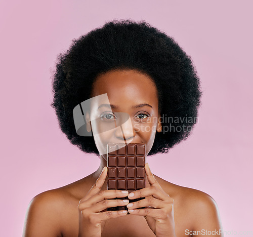 Image of Portrait, chocolate and black woman with snack, natural beauty and sugar treat on a studio background. Face, female person or Jamaican model with sweets, cocoa candy and delicious snack with calories