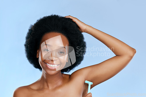 Image of Smile, portrait or black woman woman shaving armpit with a razor blade for hair removal, hygiene or wellness. Studio, blue background or happy girl model grooming underarms for healthy clean skincare