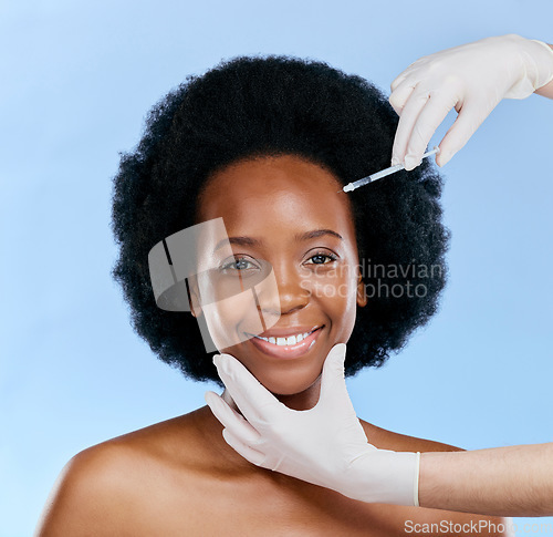 Image of Black woman, face injection and beauty with cosmetic procedure, fillers and dermatology on blue background. Liquid collagen, facial and skincare with hands, female model and smile in portrait
