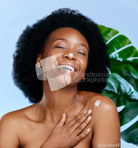 Image of Skincare, cream and woman with monstera plant for beauty, cosmetics and natural product, moisturizer or collagen. African person or model with lotion, plants and dermatology on studio blue background