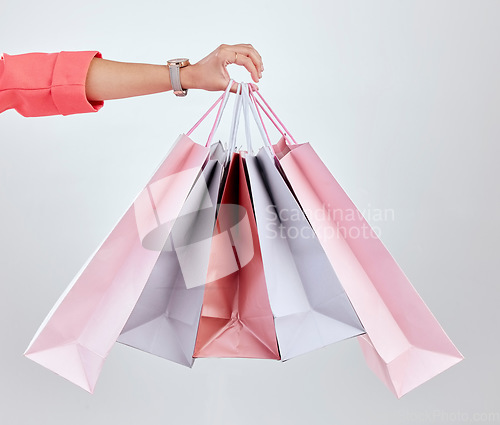 Image of Fashion, studio or hand of woman with shopping bags for retail sale, product offer or discount deal. Choice, customer or girl shopper holding gift, package or present on promotion on white background