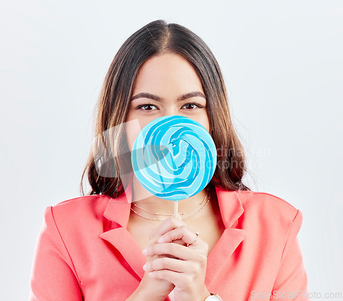 Image of Portrait, lollipop and woman with sweets, sugar and confident girl on a white studio background. Face, female person or model with candy, dessert and cover with treats, cheerful and confectionary