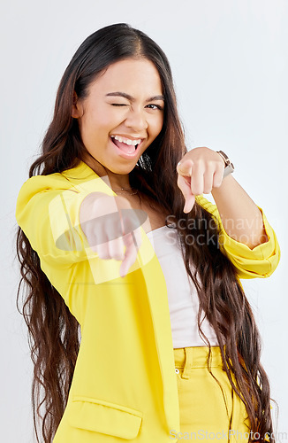 Image of Portrait, pointing and wink with an excited woman in studio on a gray background to choose you. Smile, hands and selection with a happy young female model in yellow clothes to vote on a decision