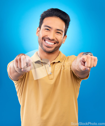 Image of Portrait, man and pointing to you in studio, blue background and hands for choice of decision, winner and volunteering opportunity. Smile, asian male model and finger emoji for recruitment of hiring