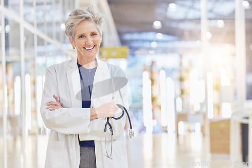 Image of Doctor, portrait and senior woman with arms crossed, happy and bokeh in hospital. Elderly surgeon, face and confident medical professional, expert or healthcare worker with stethoscope for cardiology