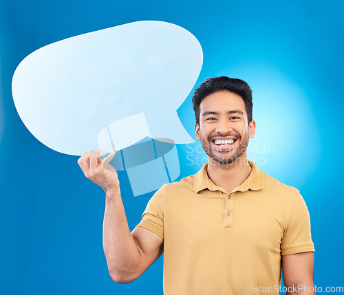 Image of Man, speech bubble and studio portrait with smile for opinion, social media and poster by blue background. Indian guy, student or model with billboard, mockup space and cardboard sign for promotion