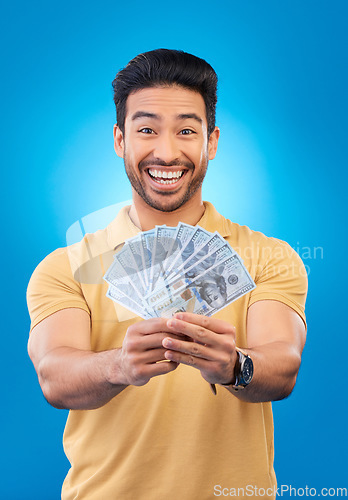 Image of Happy, portrait of a man with money fan and in a blue background for financial freedom. Rich or cash, investment or budget and male person pose for economy growth or winner in a studio backdrop