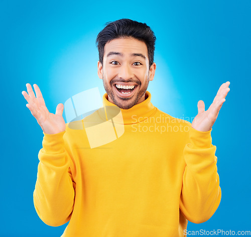 Image of Wow, excited man and surprise portrait in studio with Asian model with teeth and joy. Blue background, male person and casual fashion with handsome and friendly guy with modern style and happy