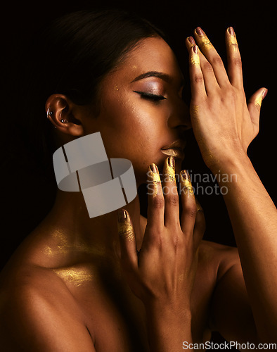 Image of Woman, gold makeup and studio for paint, beauty or body art for creativity, design and black background. Girl, model and skin with metallic texture, pattern or color for cosmetics with dark aesthetic