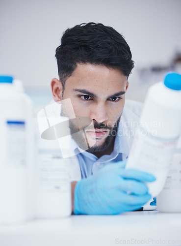 Image of Laboratory, man or scientist reading container to check medical stock or information on cure. Research study, bottle label data or science researcher in manufacturing job with chemical inventory