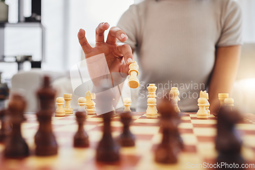 Image of Chess, game and woman with board moving piece for strategy, thinking and challenge in home. Competition, problem solving and hands of female person with chessboard in living room playing to checkmate