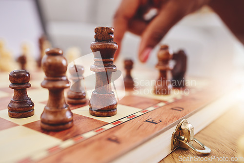 Image of Chess, game and closeup of hand with board moving piece for strategy, thinking and challenge. Competition, winning and zoom of hands of person with chessboard in living room for playing to checkmate