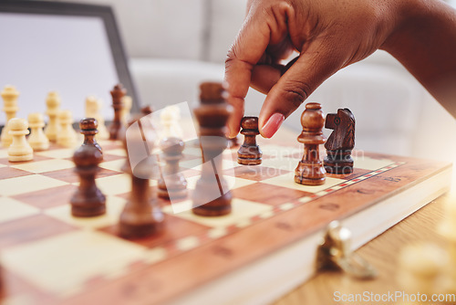 Image of Chess, move and closeup of hand with board piece for strategy, thinking and challenge on table. Competition, planning and zoom of hands of person with chessboard in living room for problem solving